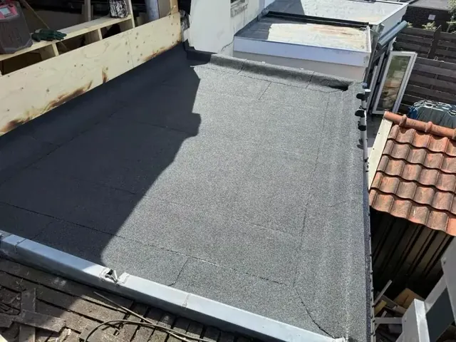 Dakrand en lichtkoepel — Een plat dakvlak met de lichtkoepel aan de andere zijde van de dakrand.